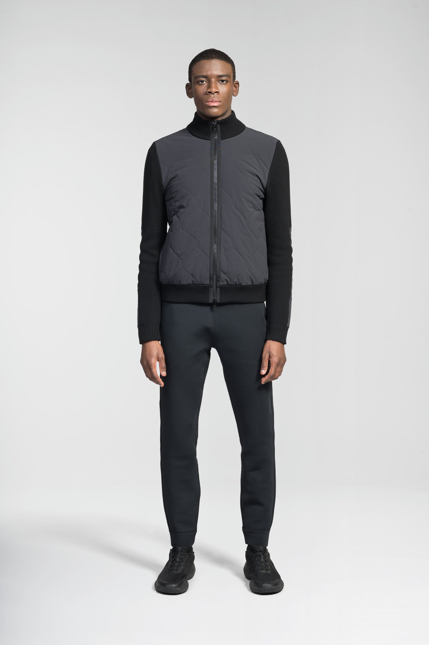 Ero Men's Tailored Hybrid Sweater in hip length, PrimaLoft Gold Insulation Active+, Durable 4-Way Stretch Weave quilted torso, Merino wool knit collar, sleeves, back, and cuffs, two-way front zipper, and hidden waist pockets, in Black
