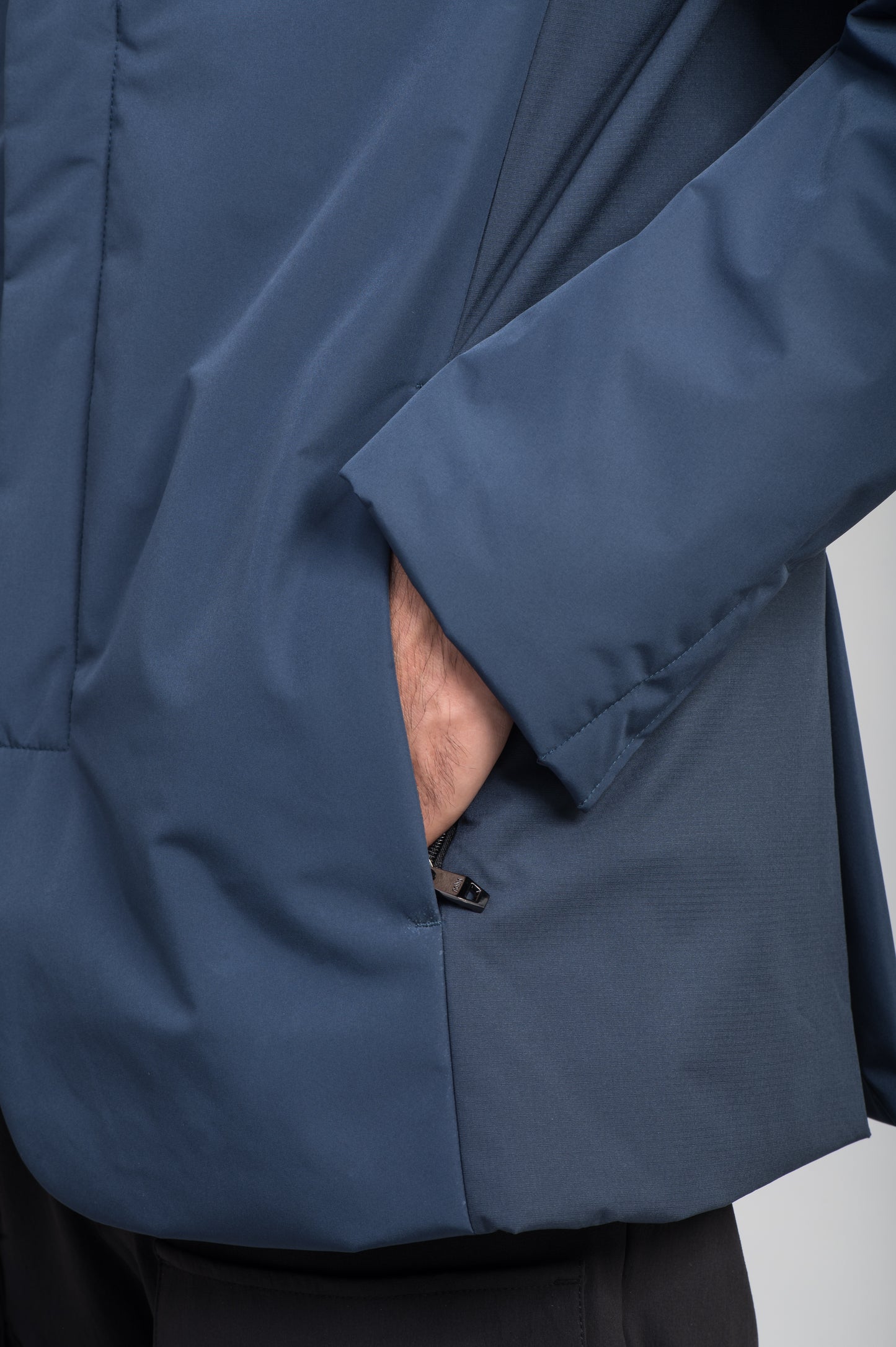 Cody Men's Tailored Travel Blazer in 3-ply micro denier and stretch nylon fabrication with DWR coating, Primaloft Gold Insulation Active+, hidden two-way zipper at centre front with snap closure placket, three invisible exterior zipper pockets, double back pleats, and hidden snap placket at cuffs, in Marine