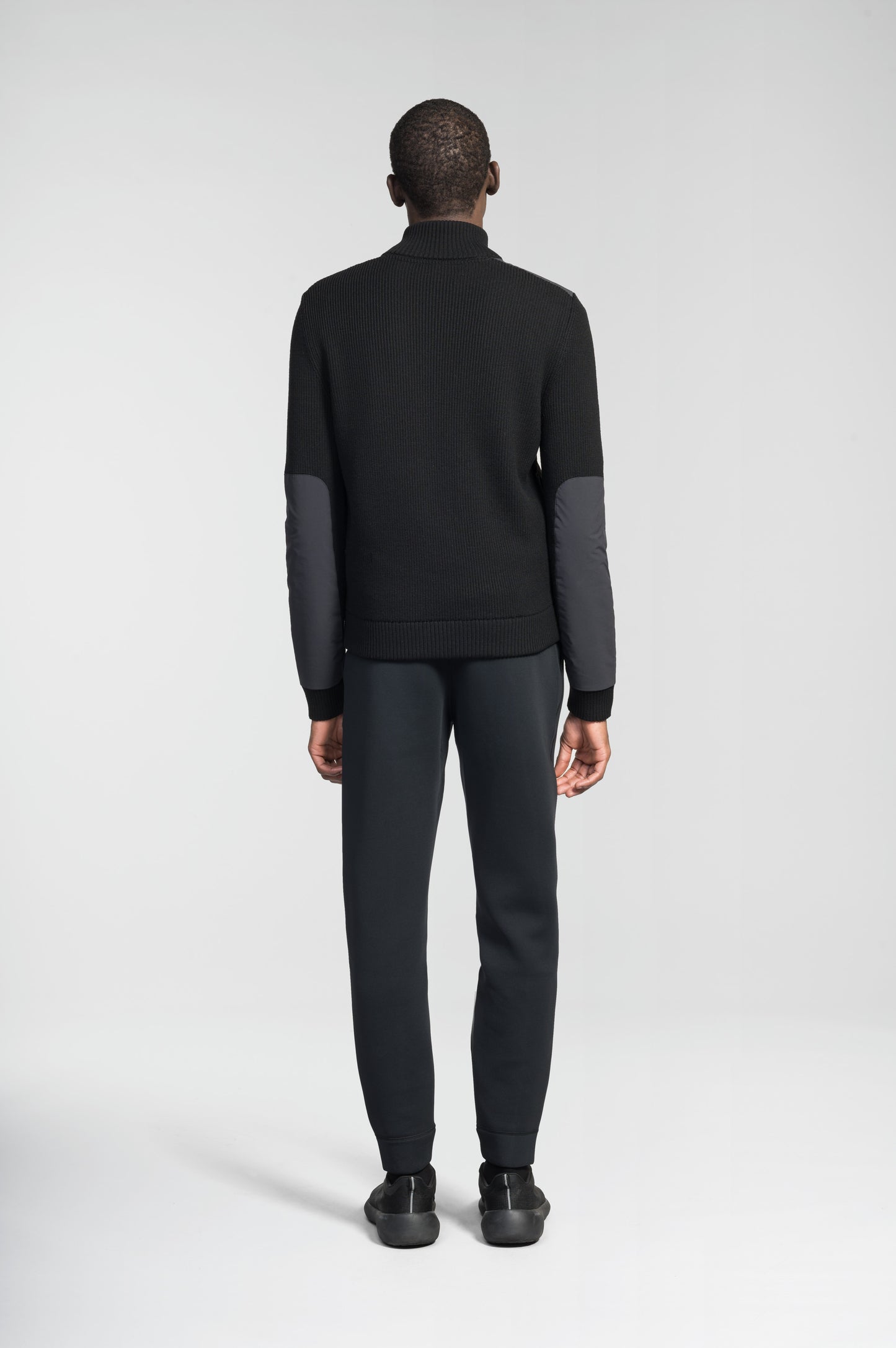 Ero Men's Tailored Hybrid Sweater in hip length, PrimaLoft Gold Insulation Active+, Durable 4-Way Stretch Weave quilted torso, Merino wool knit collar, sleeves, back, and cuffs, two-way front zipper, and hidden waist pockets, in Black