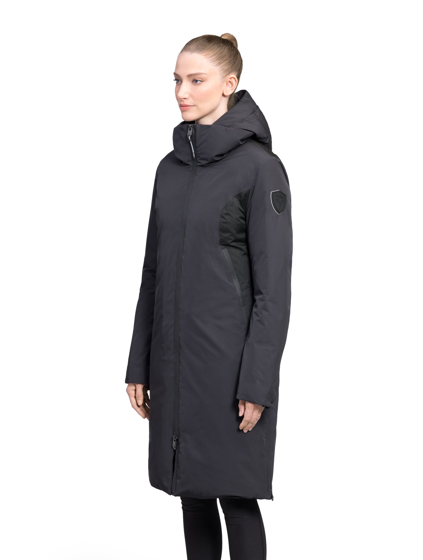 Inara Women's Performance Parka in knee length, premium 3-ply micro denier and stretch ripstop fabrication with DWR coating, Premium Canadian White Duck Down insulation, non-removable down-filled hood, centre front two-way zipper, large vertical zipper pockets along waist, zipper vents along bottom side hem, in Black