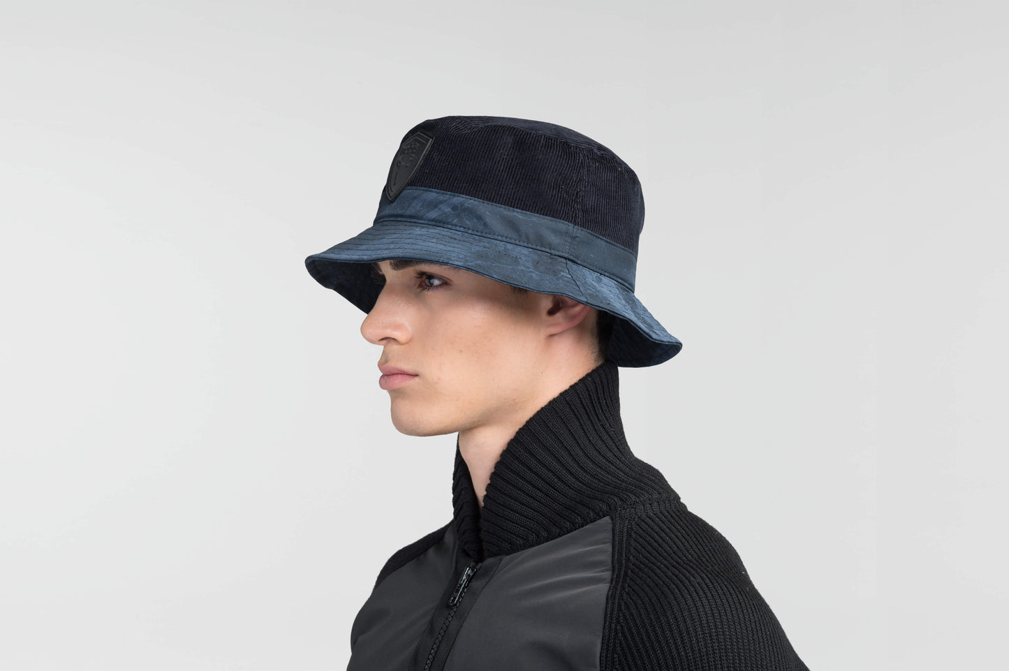 Kaia Unisex Tailored Bucket Hat in a 100% cotton corduroy and 3-ply micro denier fabrication, unstructured crown, black leather Nobis shield logo on crown front, and small flap pocket on the right side crown, in Navy