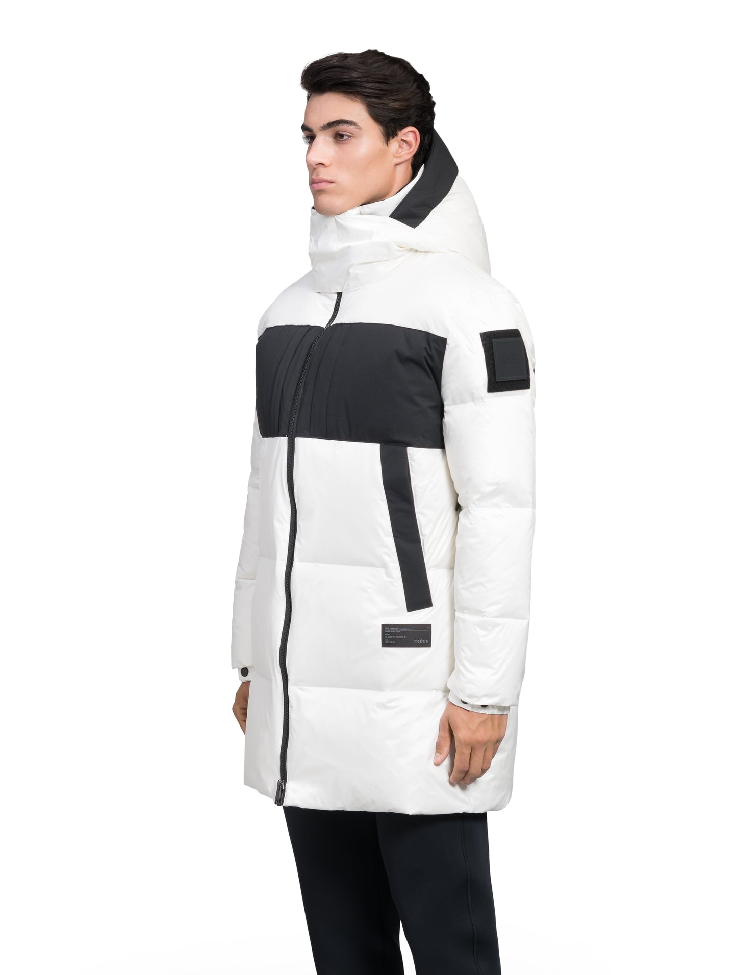 Neelix Men's Long Puffer Jacket in thigh length, premium cire technical nylon taffeta and stretch ripstop fabrication, Premium Canadian origin White Duck Down insulation, non-removable down-filled hood, two-way centre-front zipper, pit zipper vents, hidden chest zipper pockets, fleece-lined magnetic closure waist pockets, in Chalk