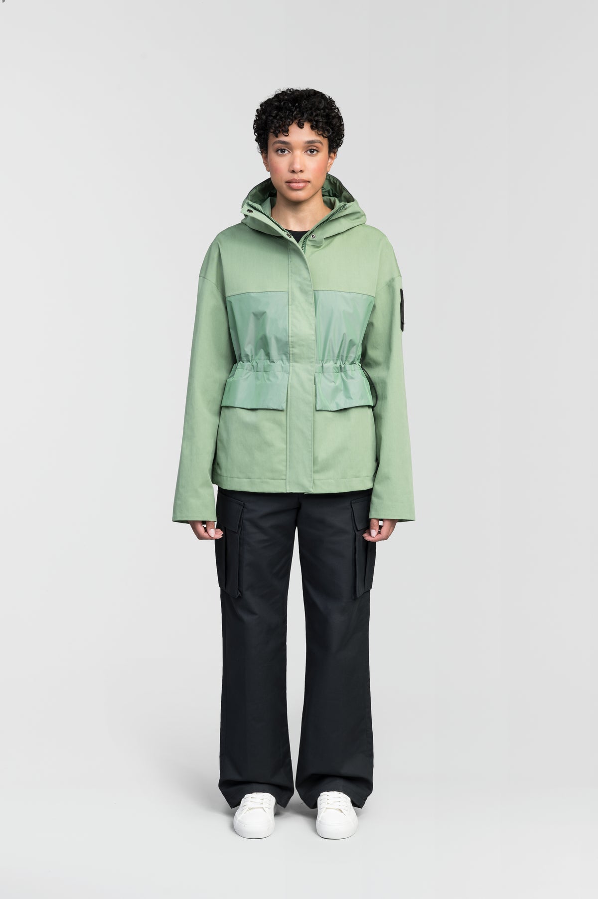 Opal Women's Performance Short Shell Jacket in hip length, premium cotton blend and contrast iridescent fabrication, adjustable drawcord at waist, non-removable hood with reflective trim, adjustable hood draw cord at interior collar, zippered side entry pockets at waist, top entry flap pockets at waist, adjustable snap cuffs, snap button wind flap, two-way branded zipper at centre front, and interior zipper pocket, in Comfrey