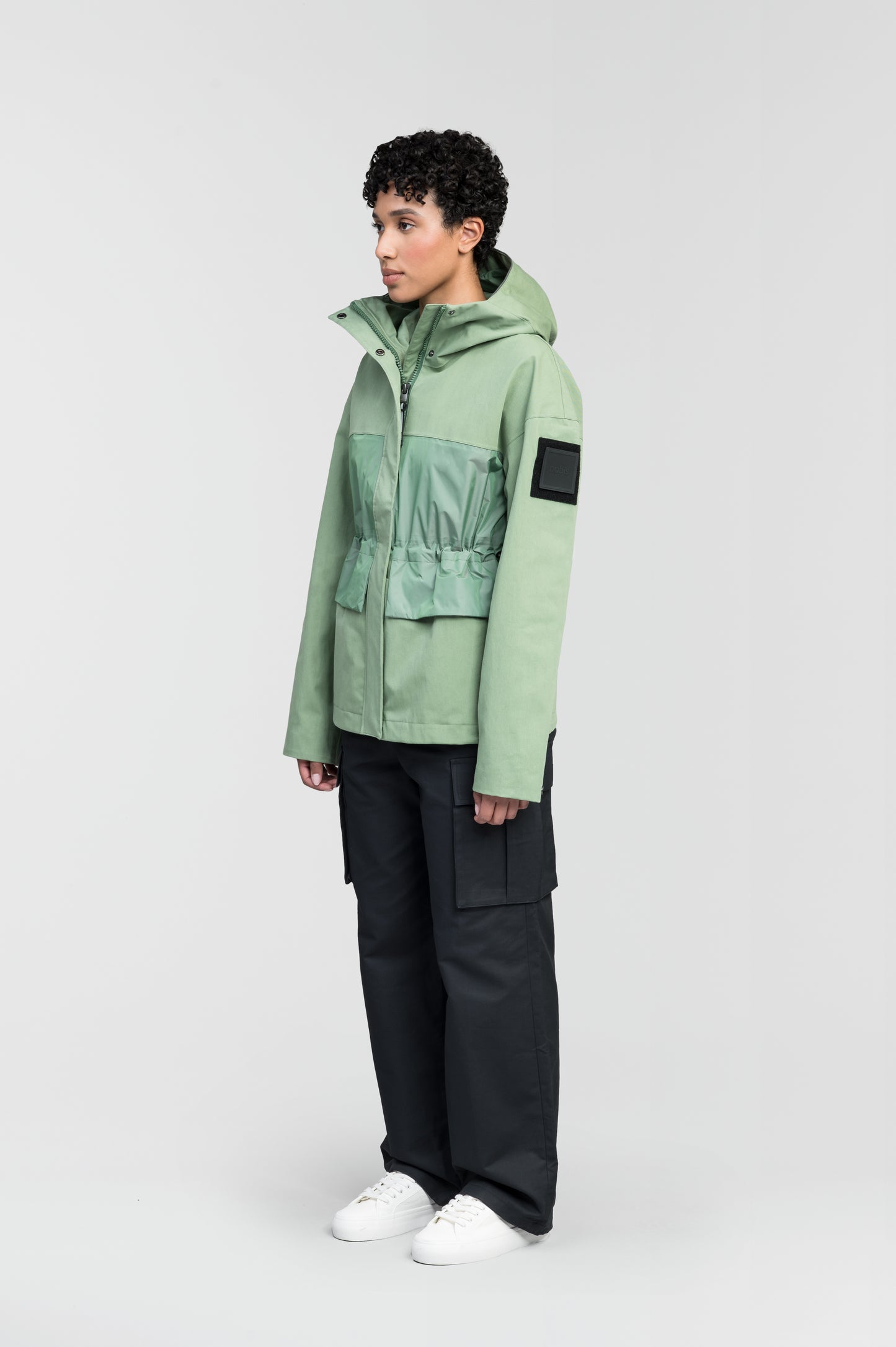 Opal Women's Performance Short Shell Jacket in hip length, premium cotton blend and contrast iridescent fabrication, adjustable drawcord at waist, non-removable hood with reflective trim, adjustable hood draw cord at interior collar, zippered side entry pockets at waist, top entry flap pockets at waist, adjustable snap cuffs, snap button wind flap, two-way branded zipper at centre front, and interior zipper pocket, in Comfrey