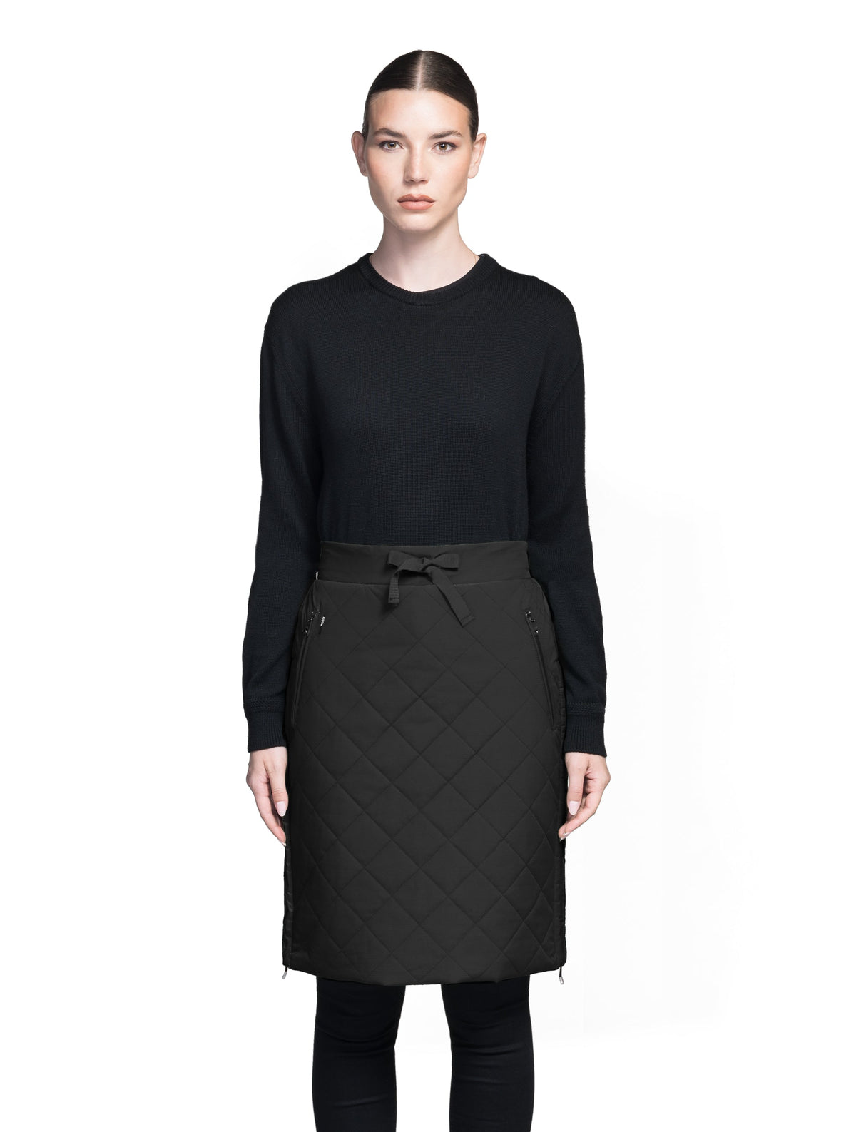 Phora Women's Tailored Skirt in knee length, premium stretch ripstop and contrast cire technical nylon taffeta fabrication, premium 4-way stretch, water resistant Primaloft Gold Insulation Active+, elasticated waistband with grosgrain ribbon drawstrings, two zipper pockets at waist, and zipper closure gusset at side seams, in Black