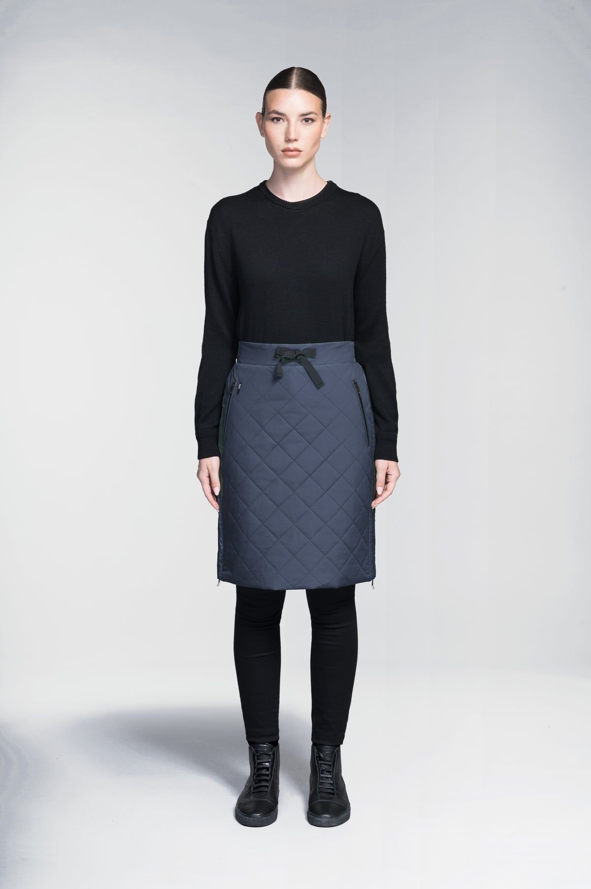 Phora Women's Tailored Skirt in knee length, premium stretch ripstop and contrast cire technical nylon taffeta fabrication, premium 4-way stretch, water resistant Primaloft Gold Insulation Active+, elasticated waistband with grosgrain ribbon drawstrings, two zipper pockets at waist, and zipper closure gusset at side seams, in Marine