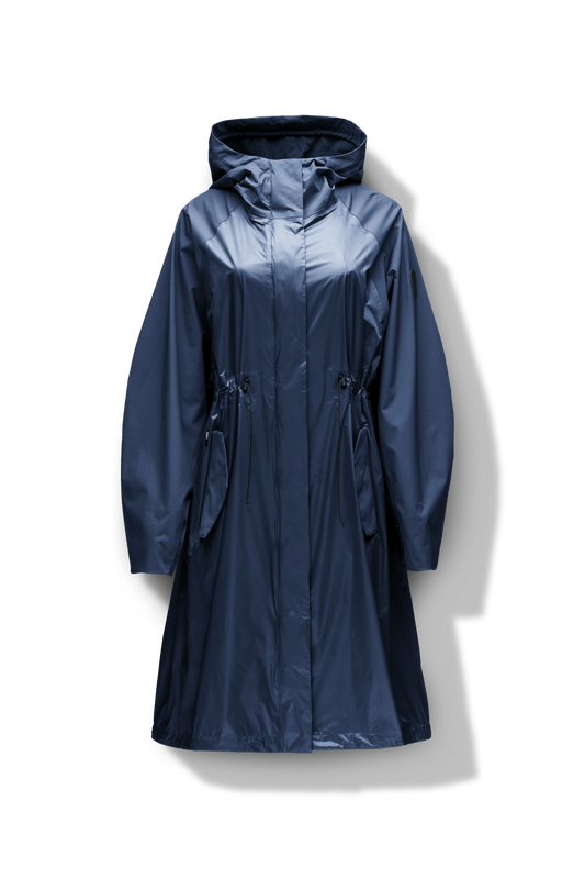 Reyna Women's Tailored Packable Long Shell Jacket in knee length, premium strech ripstop and contrast cire technical nylon taffeta fabrication, non-removable hood with adjustable draw cord, waist flap pockets with magnetic closures, adjustable draw cords at waist and bottom hem, adjustable snap cuffs, mesh back ventilation, hidden packable pocket, snap button wind flap, two-way branded zipper at centre front, adjustable snap button fishtail yoke at back, and large interior zipper pocket, in Deep Lake + Marine