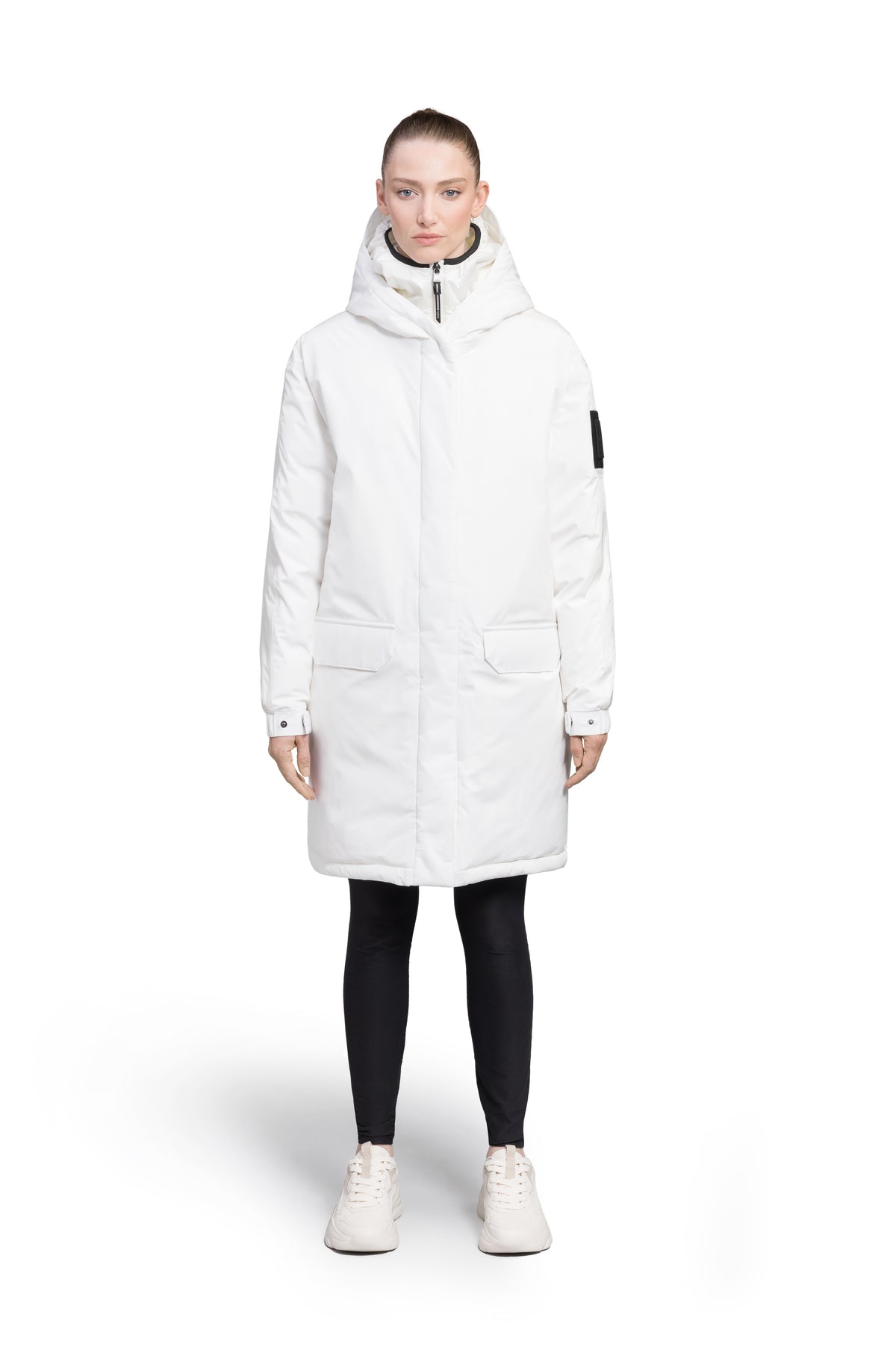 Slyn Women's Performance Parka in thigh length, premium 3-ply micro denier and cire technical nylon taffeta fabrication, Premium Canadian origin White Duck Down insulation, non-removable down-filled hood, inner hooded gilet, two-way centre-front zipper with magnetic closure wind flap, fleece-lined pockets at chest and waist, pit zipper vents, in Chalk