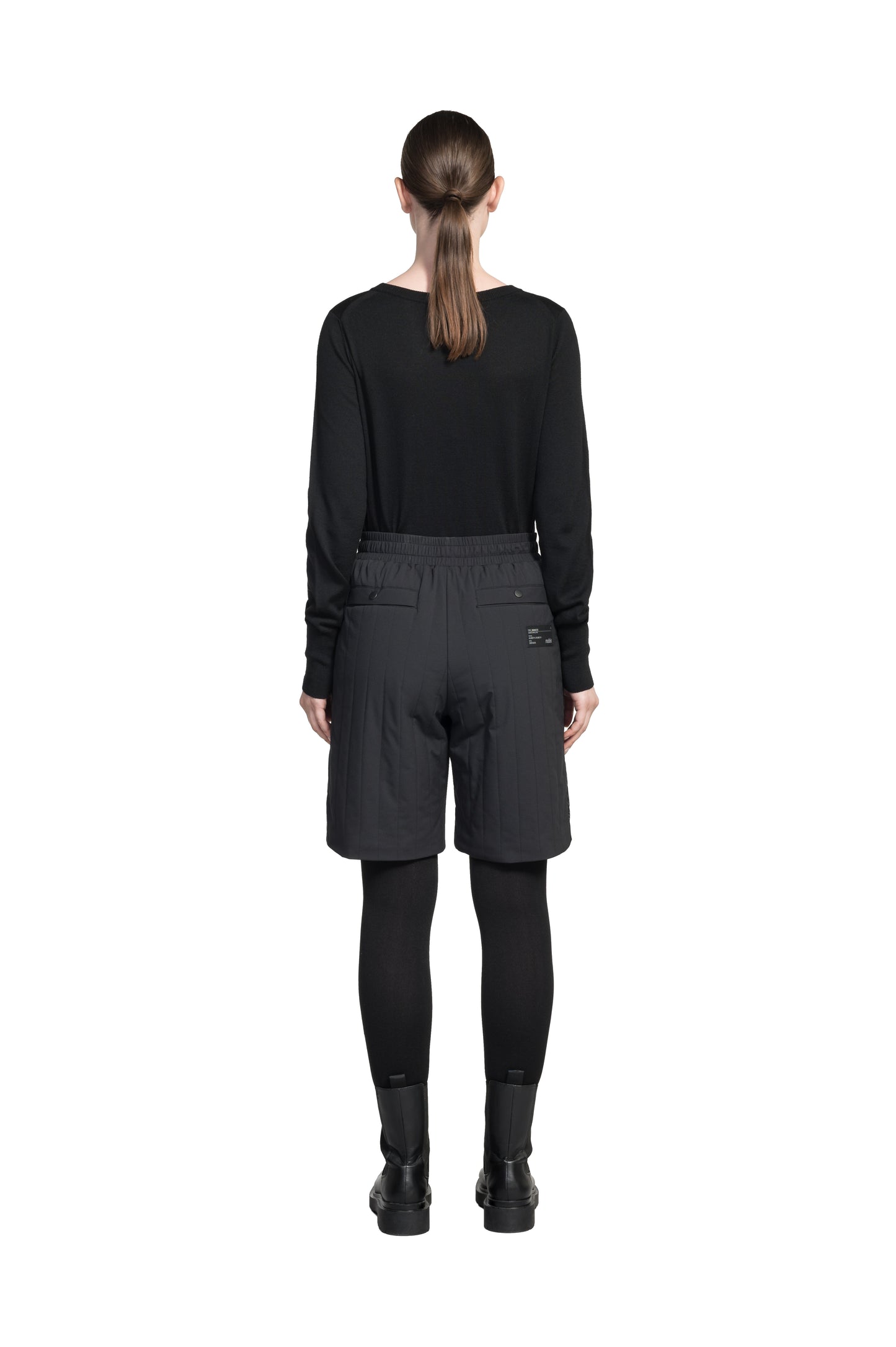 Kit Women's Quilted Shorts in knee length, premium stretch ripstop and contrast cire technical nylon taffeta fabrication, premium 4-way stretch, water resistant Primaloft Gold Insulation Active+, elasticized waistband with grosgrain ribbon drawstrings, hidden side seam toggles for rouching detail, snap closure side seam pockets at hips, and single welt snap button pockets at back, in Black