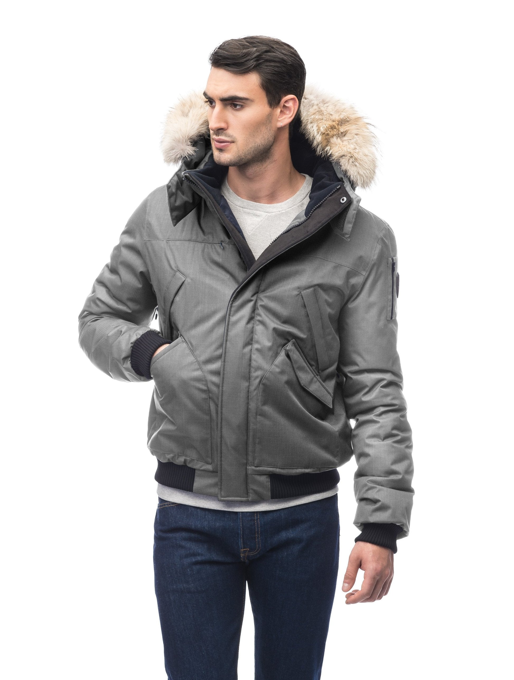 Men's classic down filled bomber jacket with a down filledÂ hood that features a removable coyote fur trim and concealed moldable framing wire in Concrete
