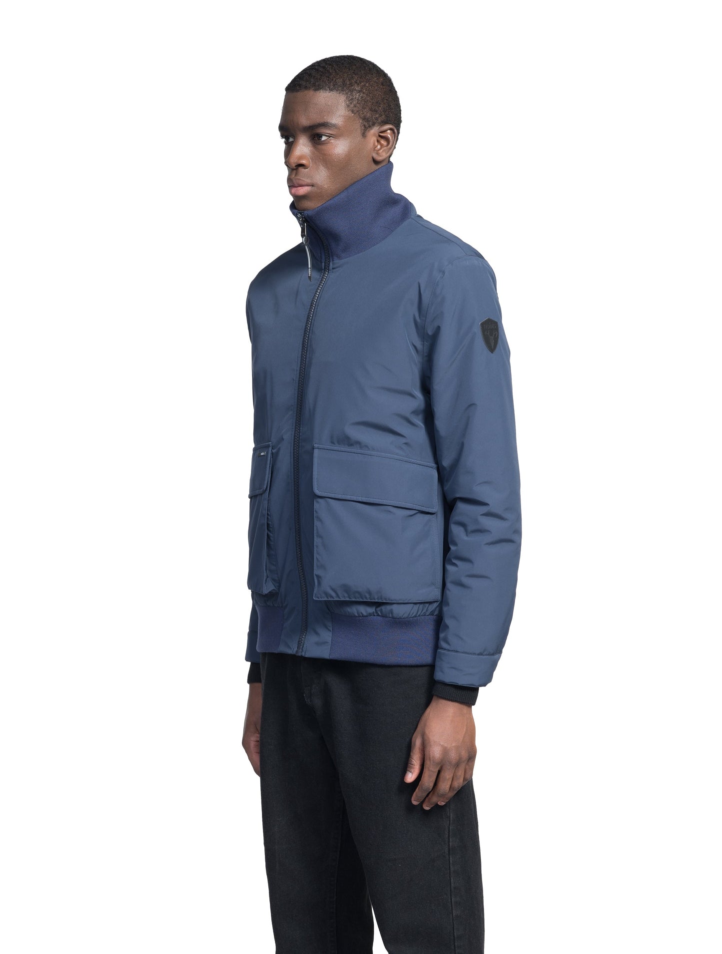 Flint Men's Tailored Rib Collar Jacket in hip length, premium 3-ply Micro Denier fabrication, premium 4-way stretch, water resistant Primaloft Gold Insulation Active +, flap pockets with magnetic closure at waist, side entry pockets at waist, ribbed sleeve cuffs, two-way branded zipper at centre front, box pleat detailing at centre back, large interior zipper pocket, and interior button pocket at left chest, in Marine