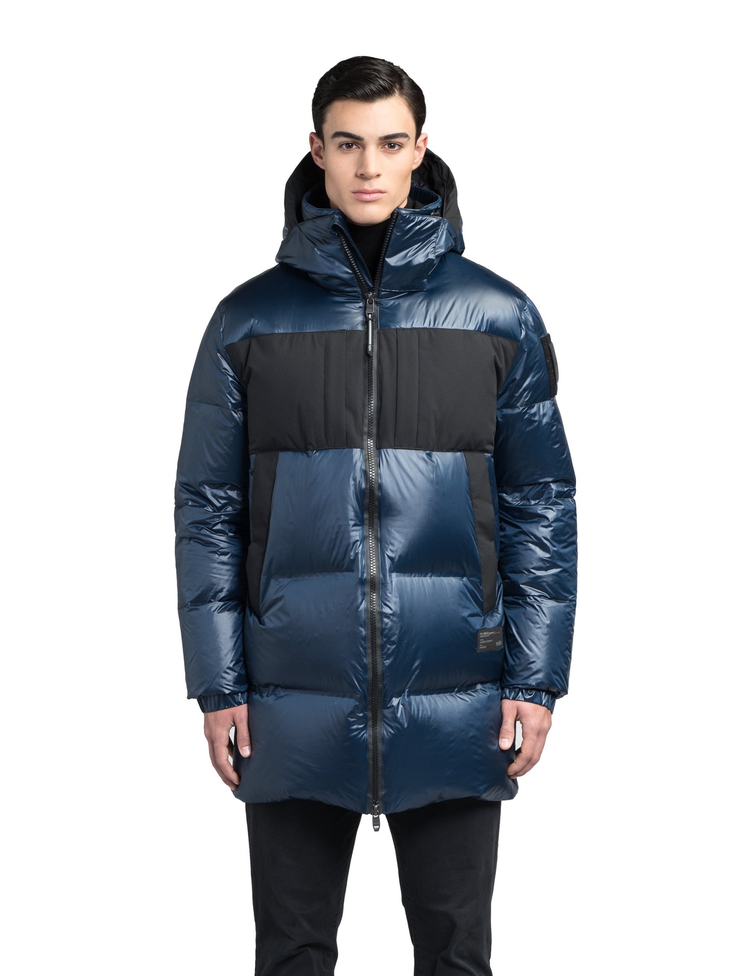 Neelix Men's Long Puffer Jacket in thigh length, premium cire technical nylon taffeta and stretch ripstop fabrication, Premium Canadian origin White Duck Down insulation, non-removable down-filled hood, two-way centre-front zipper, pit zipper vents, hidden chest zipper pockets, fleece-lined magnetic closure waist pockets, in Marine